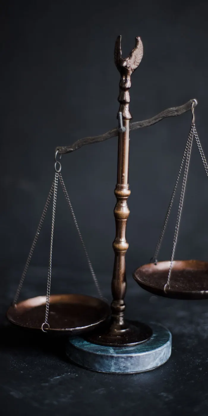 Balança da justiça em bronze sobre fundo escuro